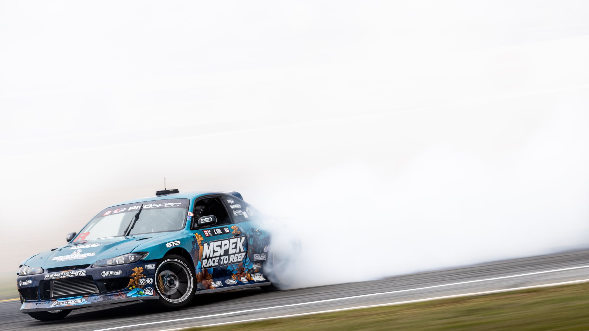 The Race to Reef S15 mid-drift at speed, tyre smoke across the track
